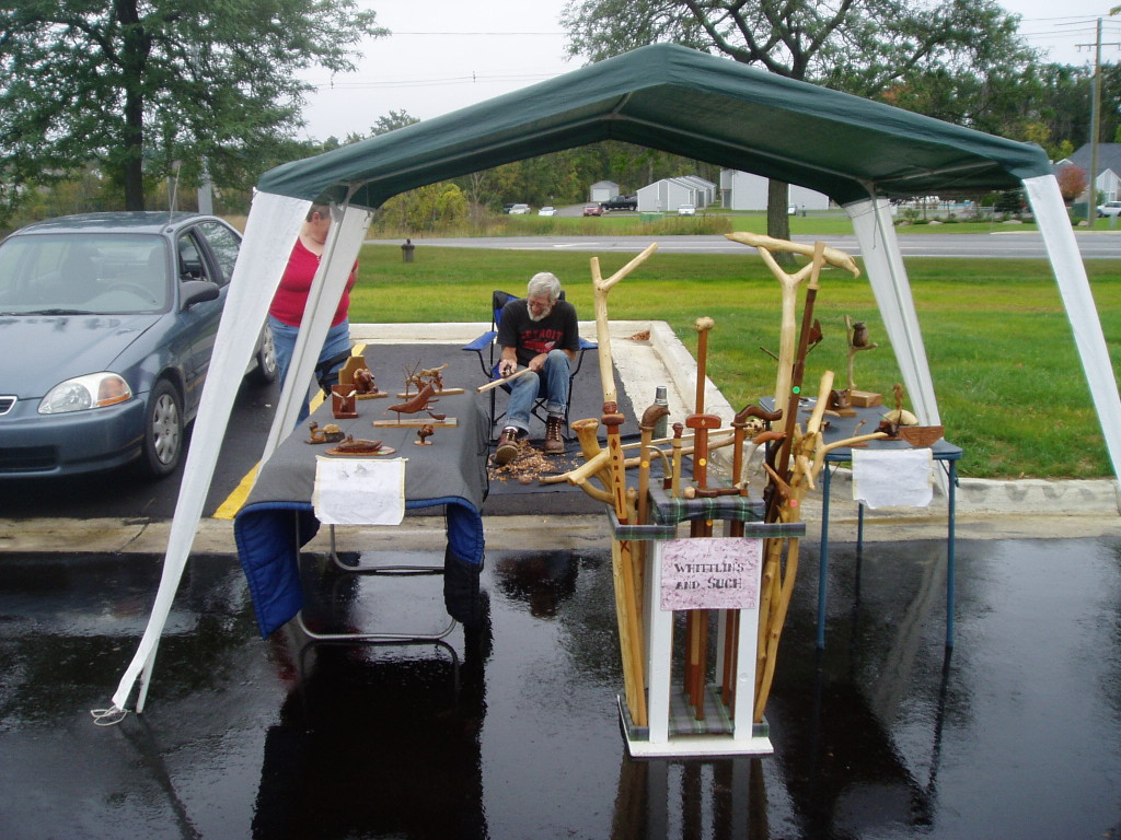 A display of wood works while Jock the carver works on a piece.