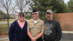 Steven in his Navy clothes staniding between his dad and mom