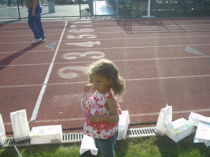 young girl helping set luminary bags back up